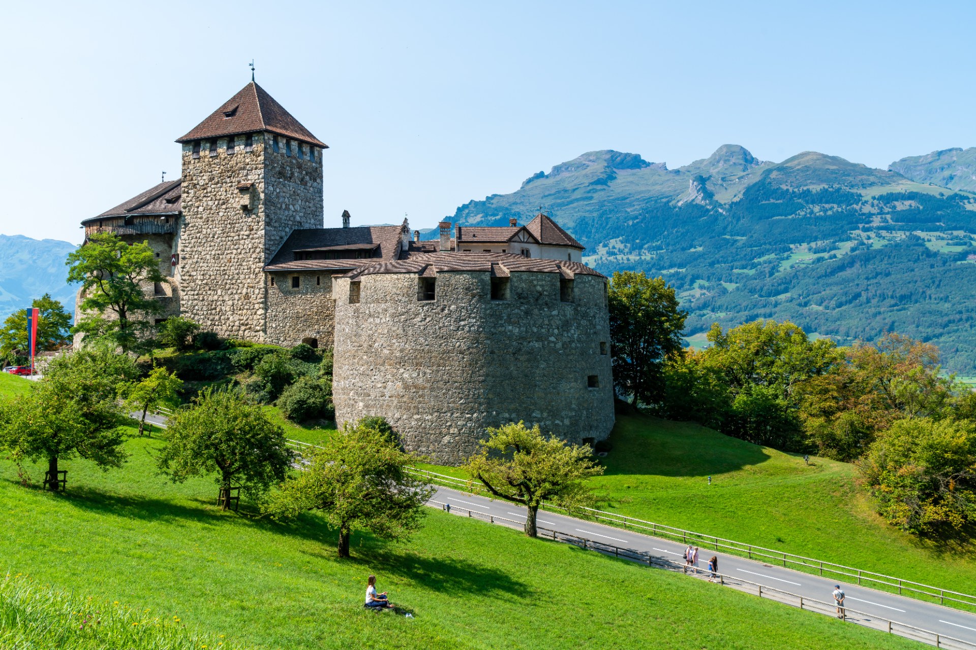 Hrad Vaduz na zeleném svahu na pozadí hor v Lichtenštejnsku